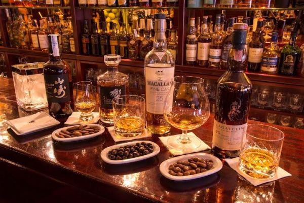 Custom-made cocktails at a sleek, vintage-style bar with leather & velvet furnishings.